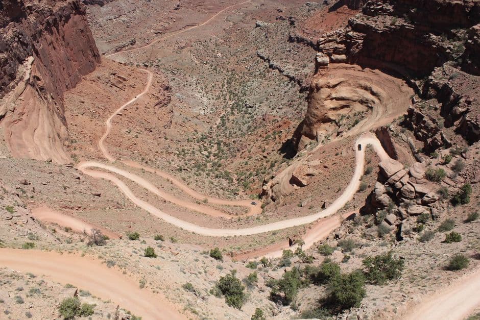 Aerial shot of winding Shafer Trail in Canyonlands National Park, Utah, showcasing stunning desert landscape.
